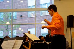 Senior Jared Perlo conducts the Wind Ensemble in POPS Night