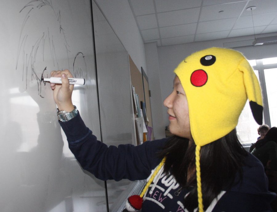 Freshman Joanna Le draws on the white board during Japanese film and anime club.