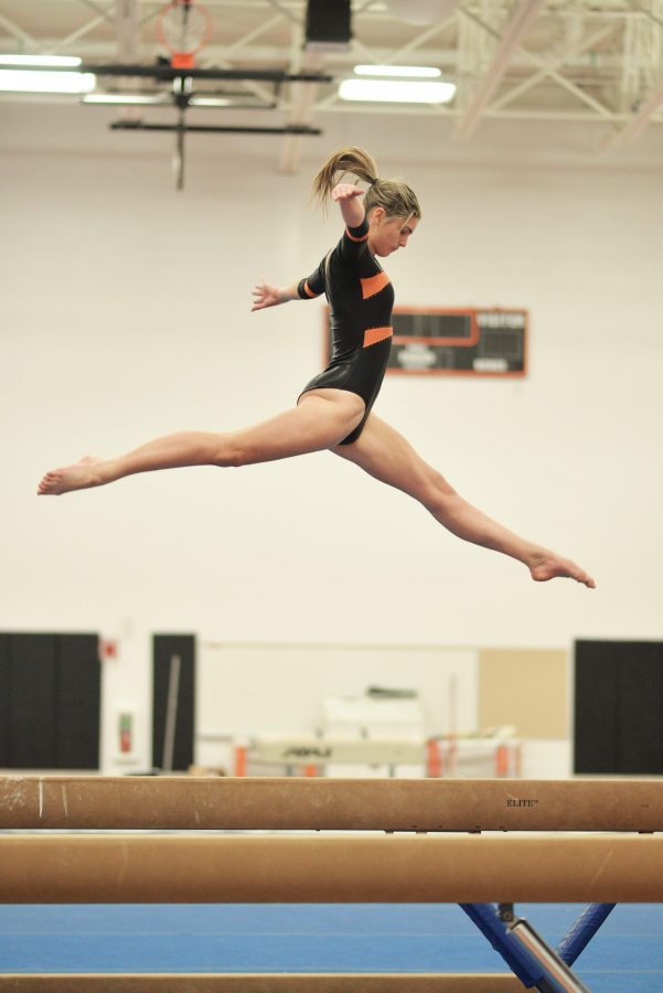 Sophomore Calley Dias performs a split leap during her beam routine Jan. 7 against Framingham. Photo by Judith Gibson-Okunieff.