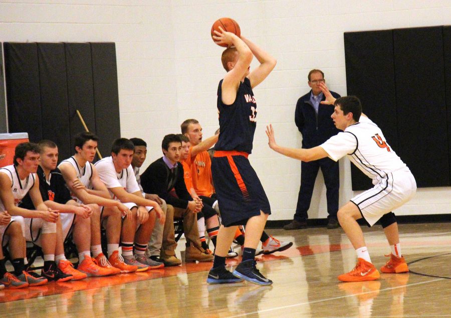 Senior Brett Stanton defends a Natick forward during the Tigers 109-52 win over the Red Hawks.