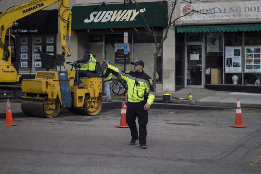 A Newton Police officer directs traffic around the site of a hazardous material spill Thursday morning, November 17. Photo by Josh Shub-Seltzer.