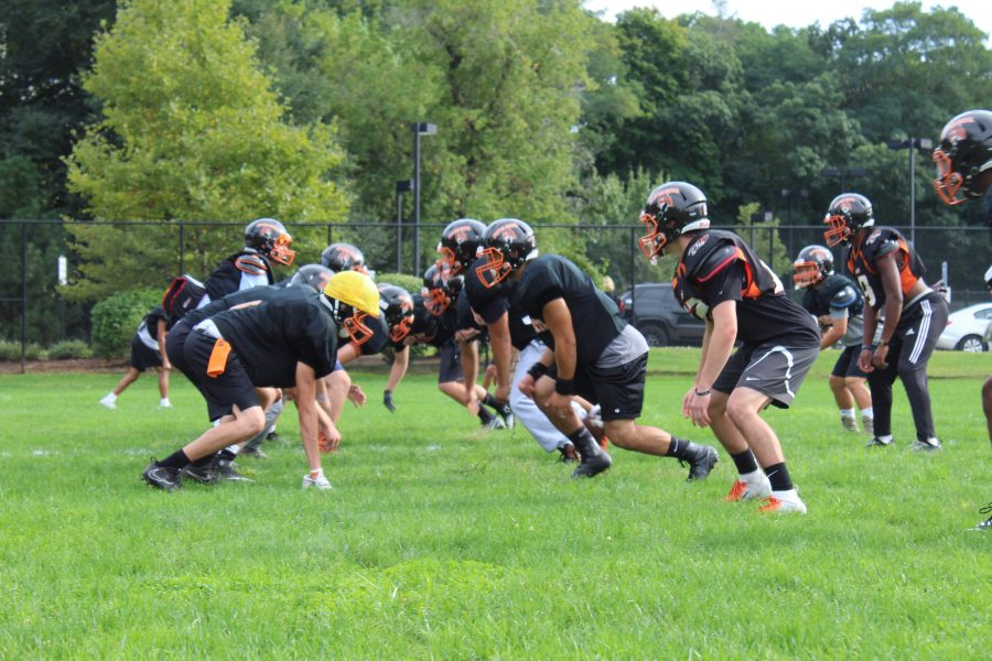 Varsity football lines up to practice a play. (Photo by Joelle Sugianto)