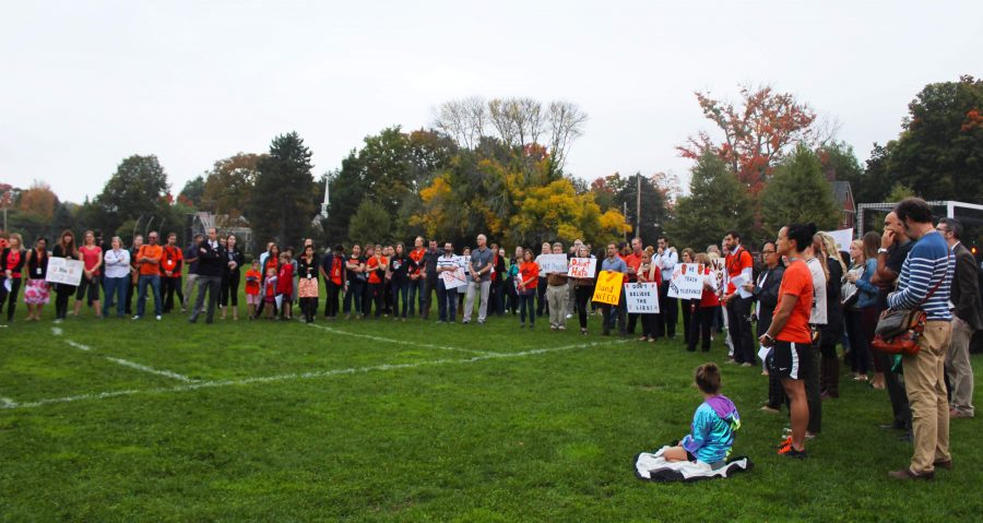 Teachers gather on the field before school with posters of support. (Photo by Joelle Sugianto) 