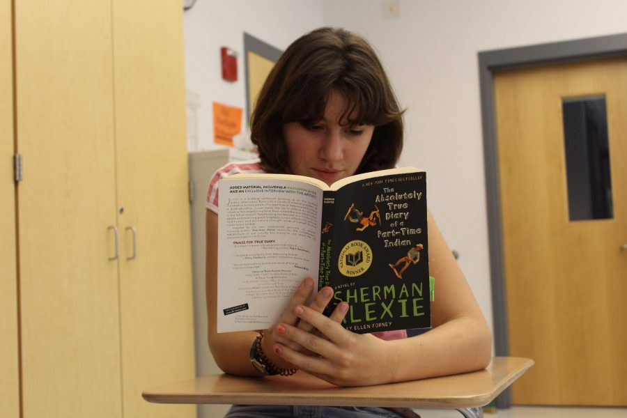 Junior Maggie Needham reads Absolutely True Diary of a Part-Time Indian. (Photo by Joelle Sugianto)