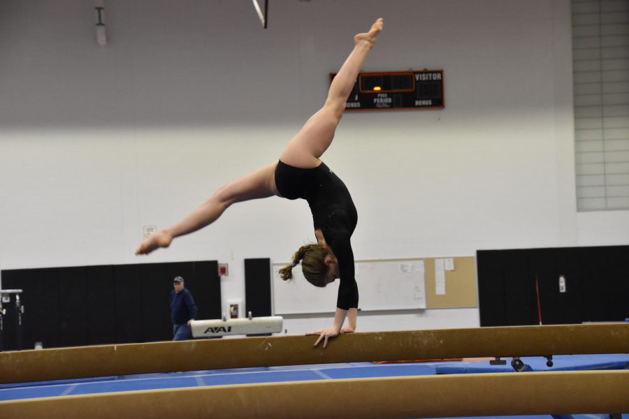 Junior Izzy Day completes her beam routine during last weeks meet against South. (Photo by Julia Bu)