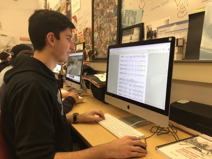 Senior Ben Gobler, co-director of the Melocotones a capella group, arranges music in the graphic communications room Friday, March 8. 