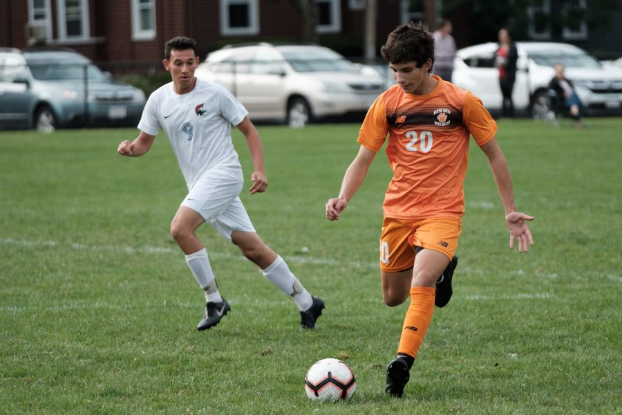 Sophomore Will Rooney prepares to pass the ball in a game against Brookline Thursday, Sept. 12. (Photo by Ian Dickerman).