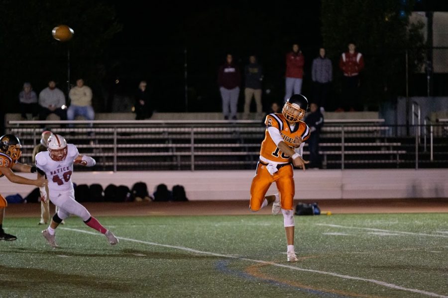 Senior Andrew Landry, a captain with seniors Nolan Boyer and Michael Coscione, attempts a pass in the annual Friday Night Lights Game against Natick on Friday, Nov. 18.