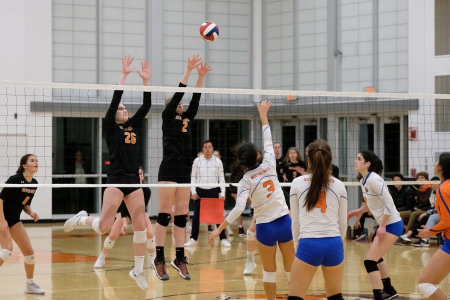 Seniors Caroline Alexander and Kayla Rigoli go up to the net for a block during the quarterfinals of the MIAA Central/East Division. Photo by Ian Dickerman