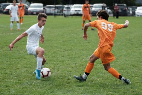 Junior Andrew Nielsen steps up to steal the ball during a game last year against Brookline September 12, 2019. Boys soccer will begin training for the new season in the coming week. (photo by Ian Dickerman)