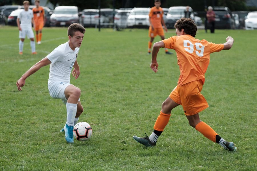 Junior Andrew Nielsen steps up to steal the ball during a game last year against Brookline September 12, 2019. Boys soccer will begin training for the new season in the coming week. (photo by Ian Dickerman)
