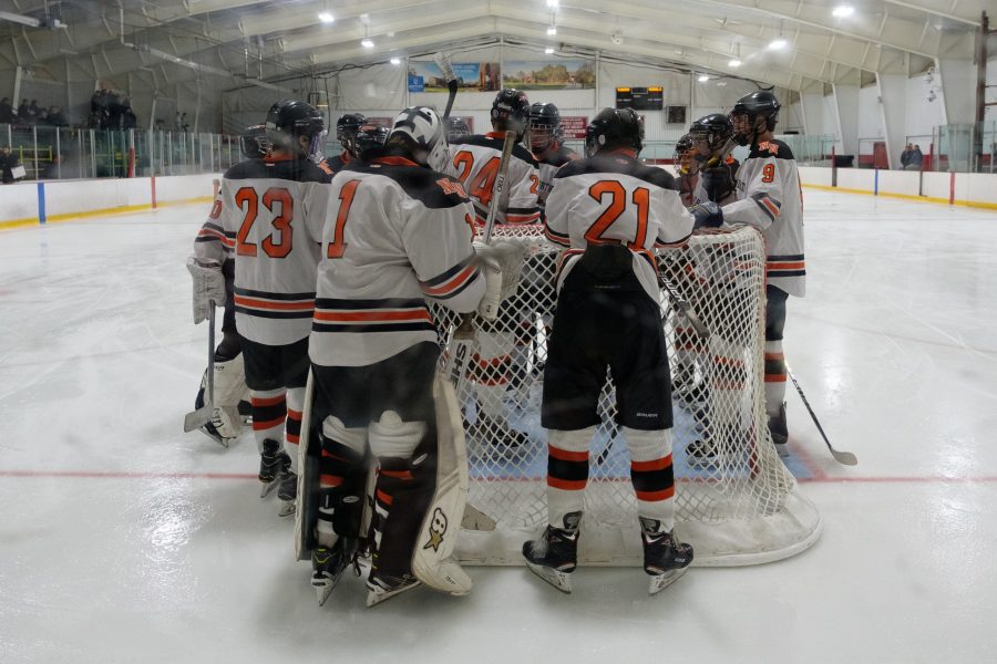 Boys' hockey huddles, preparing for a game, last season. (Photo by Ian Dickerman)
