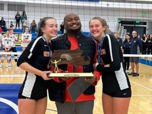 Senior Abigail Wright (right) and junior Katelin Simmons (left) celebrate their victory with head coach Nile Fox.