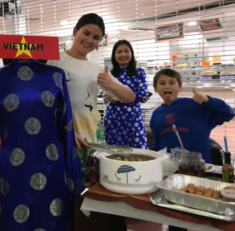 A family poses behind the Vietnam booth at Multicultural Night Tuesday, Nov. 15.
