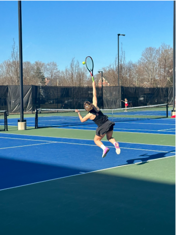 Junior Betina Kreiman reaches to hit a tennis ball during a match against Natick, Monday, April 10