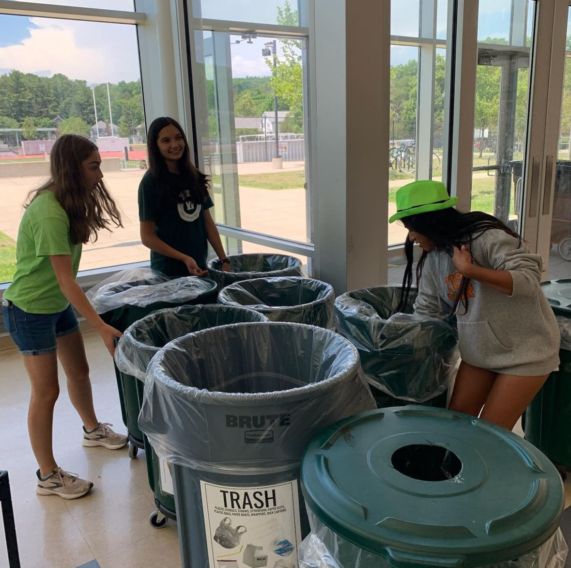 Juniors Ella Chen, Carolina Darcy, and Caitlin Riordan, members of the Sustainable Development Club, bring composting bins into the cafeteria Wednesday, Nov. 22.
