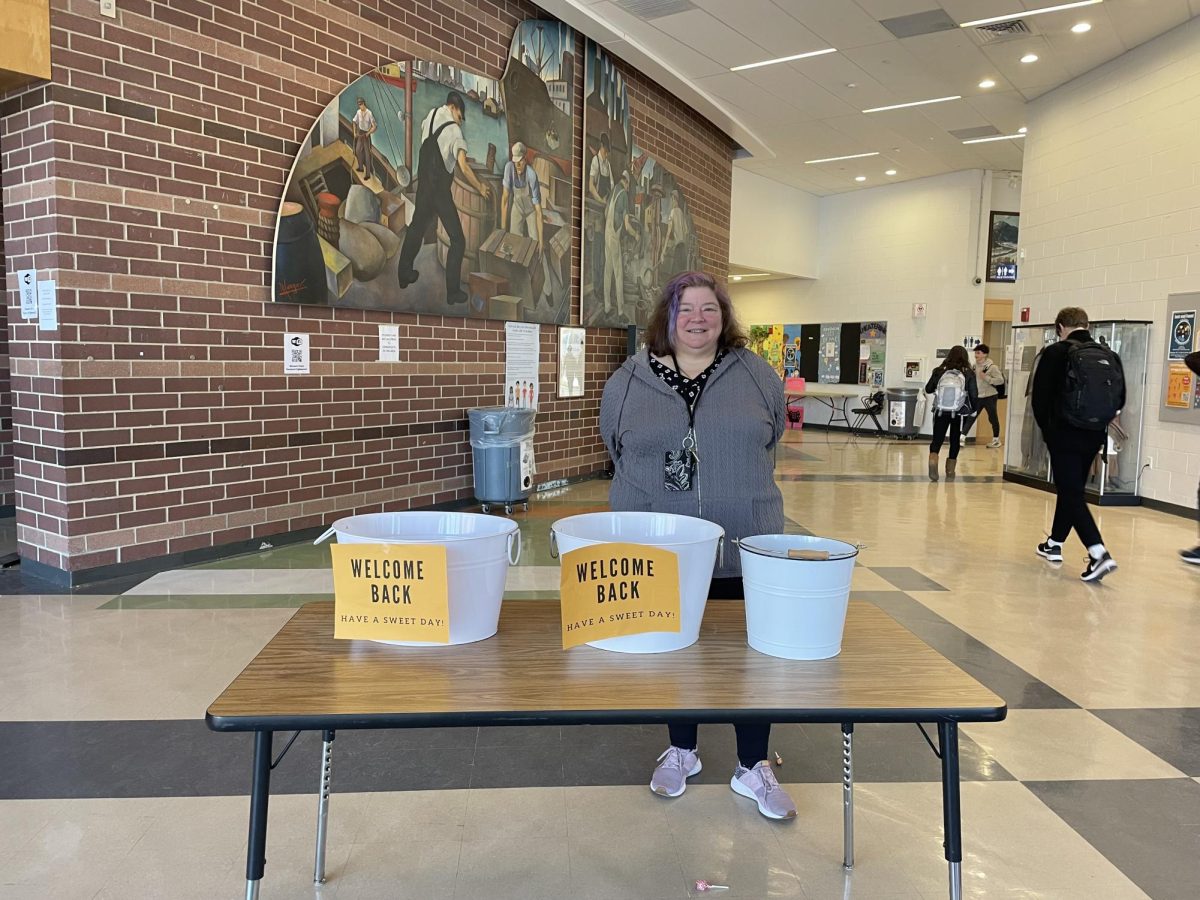 Beals House Executive Assistant Cheryl Stover hands out treats to welcome students back to school following the end of the union strike Monday, Feb. 5.