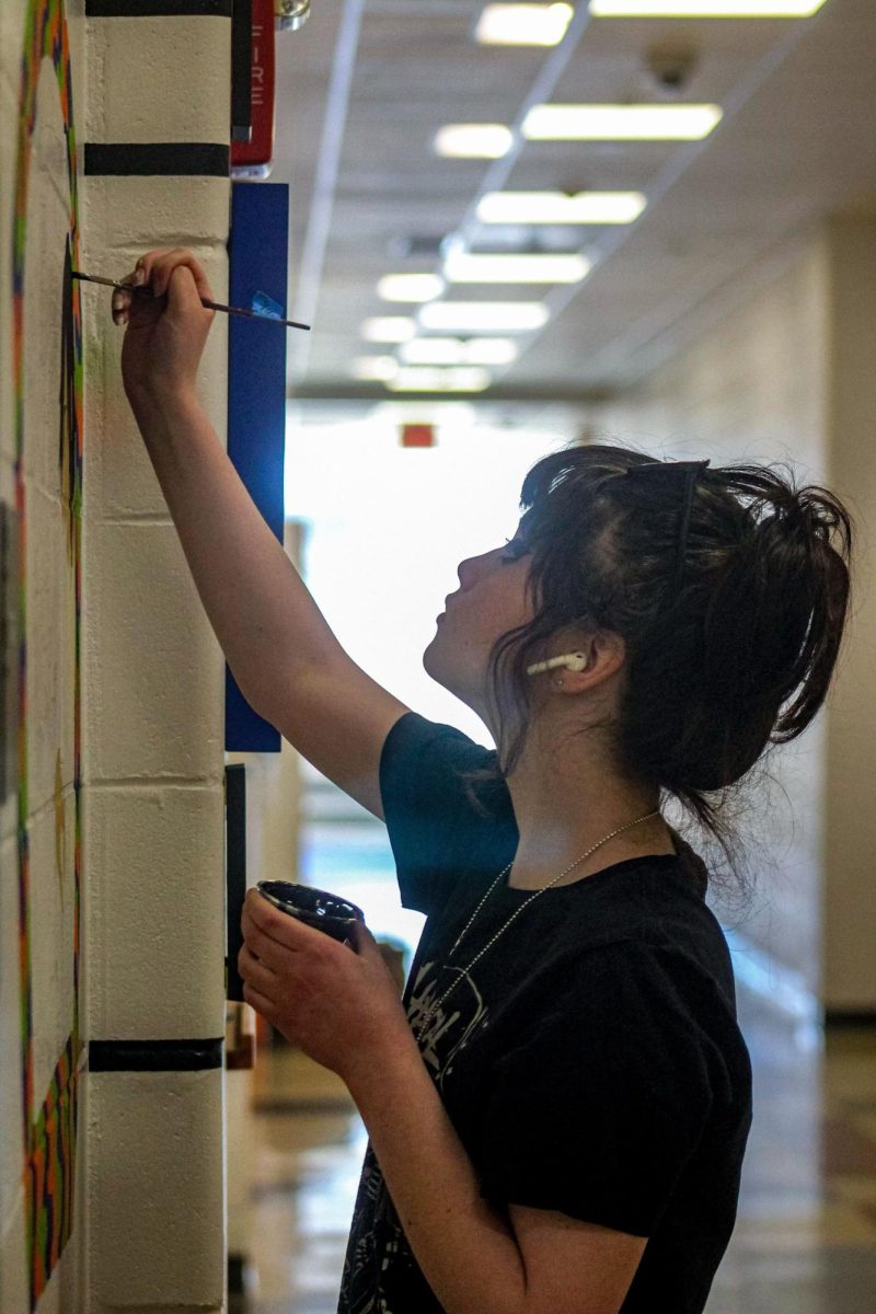 Senior Stephanie Fraktman paints a mural of musicians in the art wing on Thursday, March 21. 