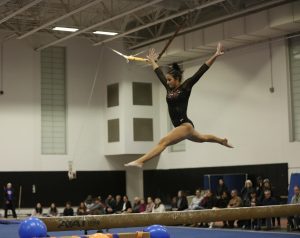 Sophomore Lucia Grapski leaps above the beam at the team's meet against Natick Tuesday, Jan. 28. 