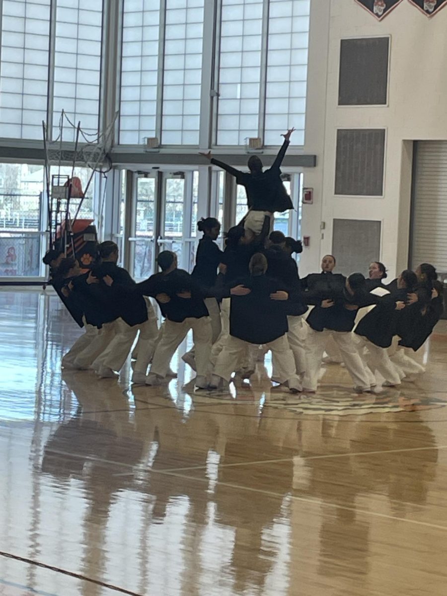 Members of the dance team lift freshman Maeve Pelis mid-way into their routine Saturday, Feb. 8. 