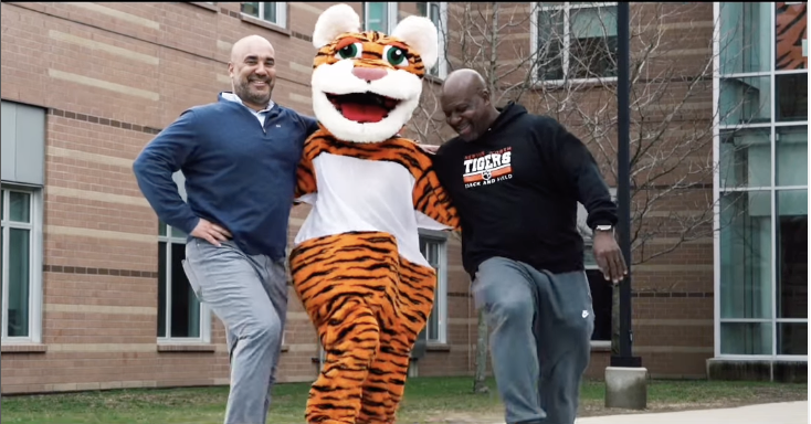 Principal Henry Turner and Athletic Director Mike Jackson join a kickline with the tiger mascot, Sunday, May 4. 
