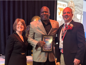Athletic Director Mike Jackson poses with his award alongside District 7 Councilors, Friday, March 28. 