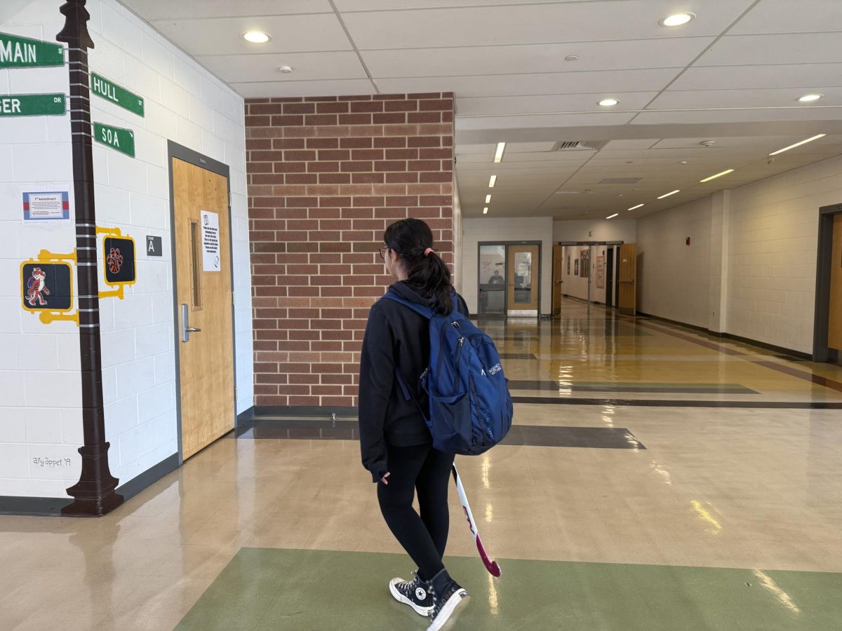 A student carries her field hockey equipment while heading to the locker rooms Monday, Sept. 22. 