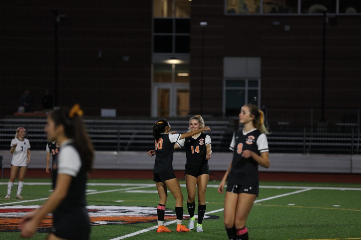 Senior Shiaowei Qu embraces senior Clara Binne after she takes the kickoff, Thursday, Oct. 23.