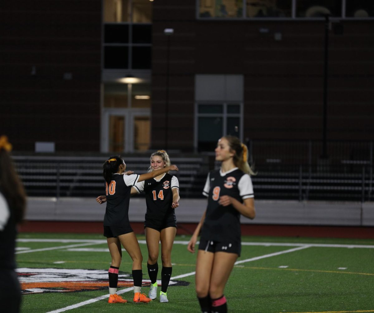 Senior Shiaowei Qu embraces senior Clara Binne after she takes the kickoff, Thursday, Oct. 23.